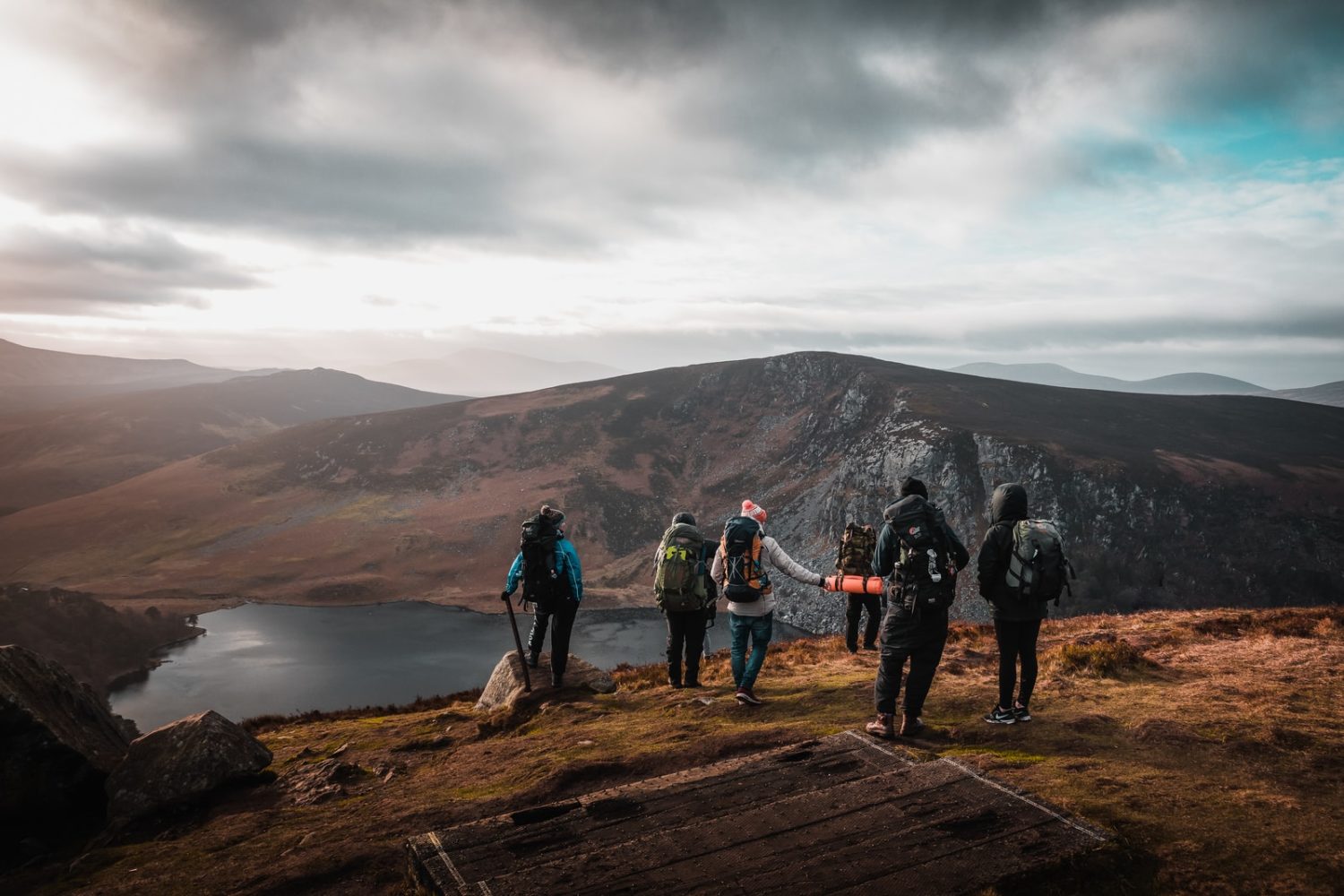 group of people on top of mountain under gray sky